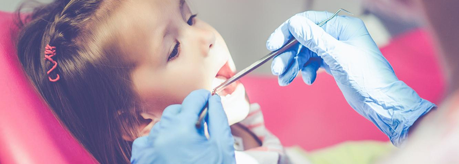 gentle kids dentist checking child teeth in Bayside dental clinic